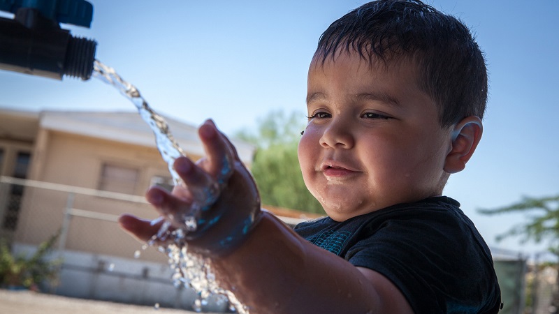 Boy at clean water pipe