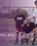 an adult and two kids with a basketball in a park