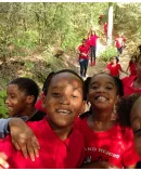 smiling children walking together on a wooded trail