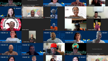 Zoom gallery view showing dozens of meeting participants in a grid, many smiling on camera, some muted, with virtual backgrounds.